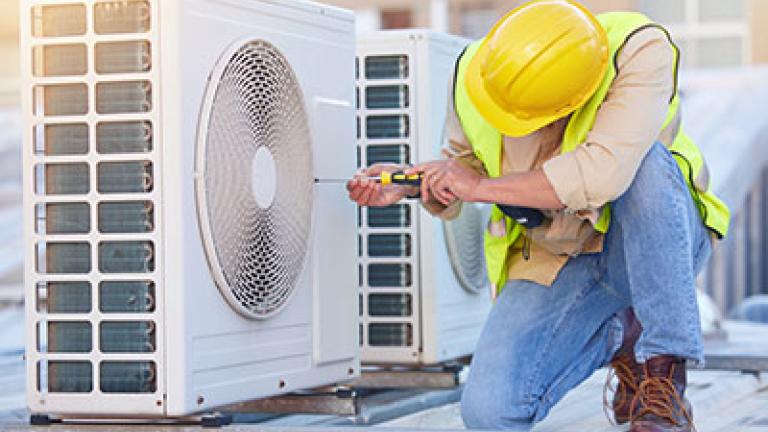 man working to repair AC unit